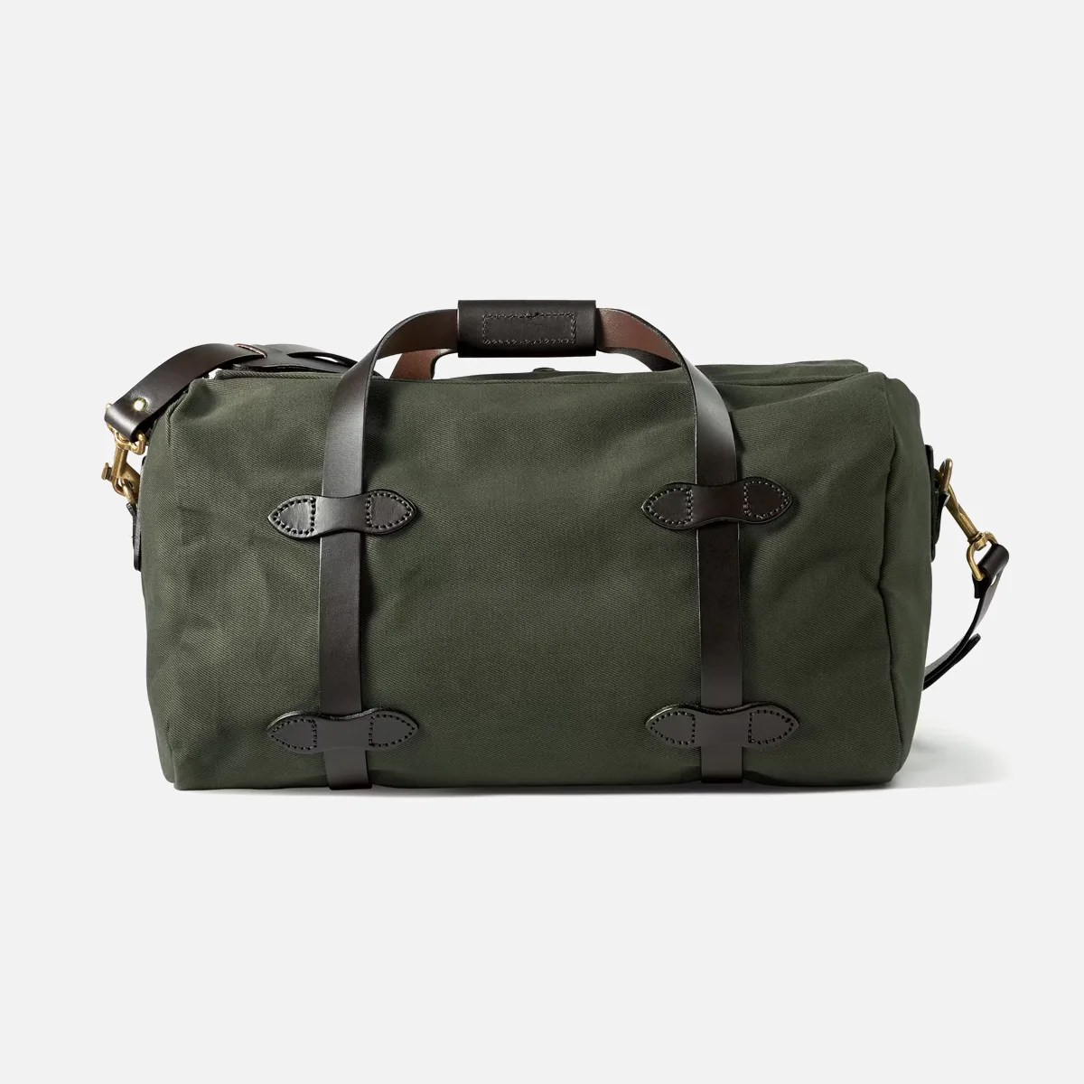 Olive green canvas duffel bag with dark brown leather straps and brass hardware on a white background.