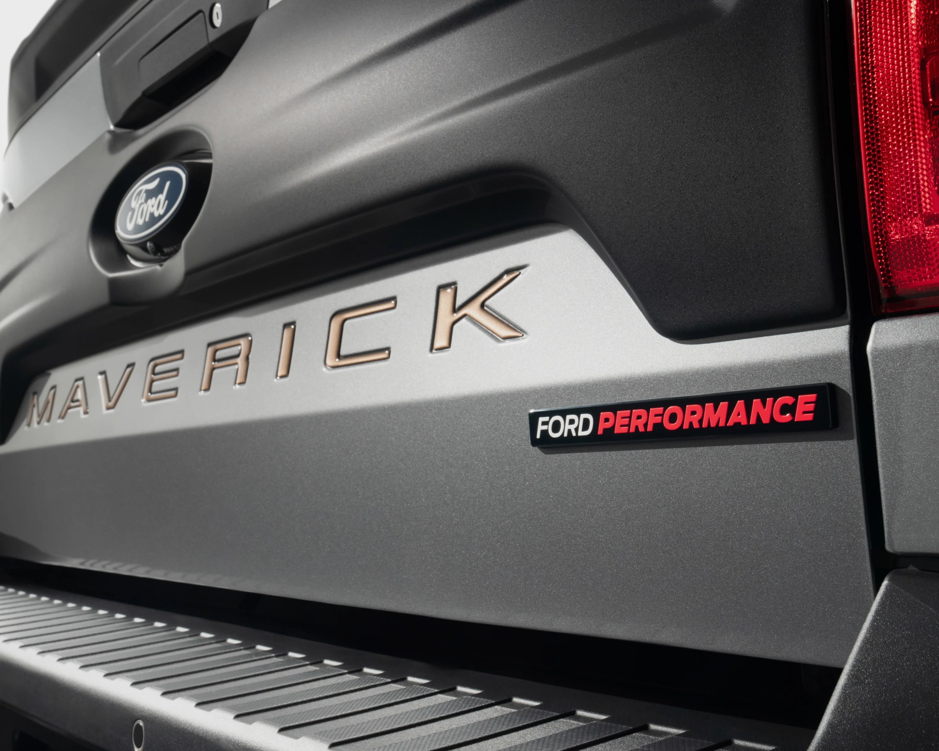 Close-up of the rear tailgate of a gray Ford Maverick with "Ford Performance" badge and red taillight.