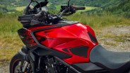 Red and black Honda CB1000R ST motorcycle fuel tank and seat with digital display on handlebars.