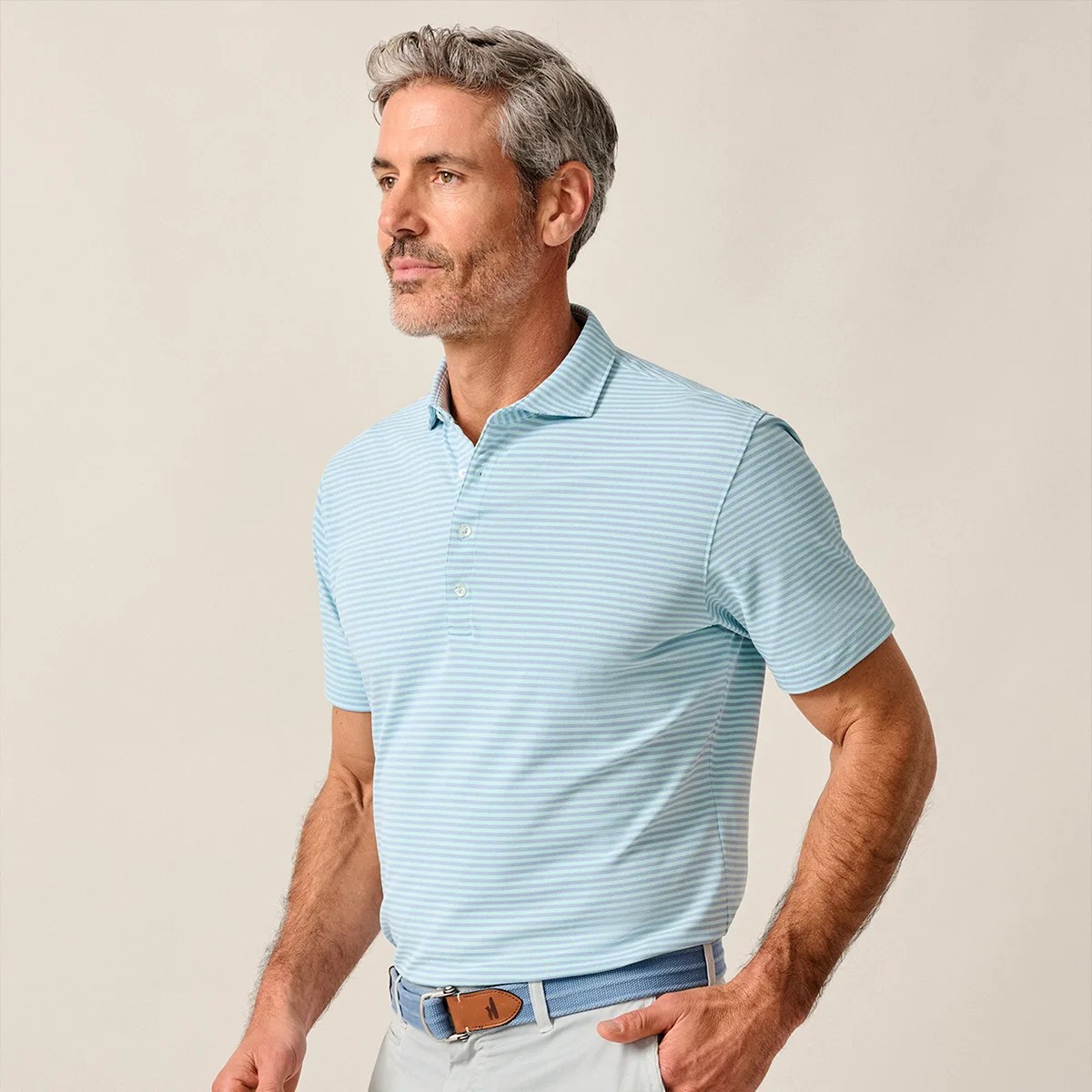 Light blue and white striped short-sleeve polo shirt worn by a person with a blue belt and light pants.
