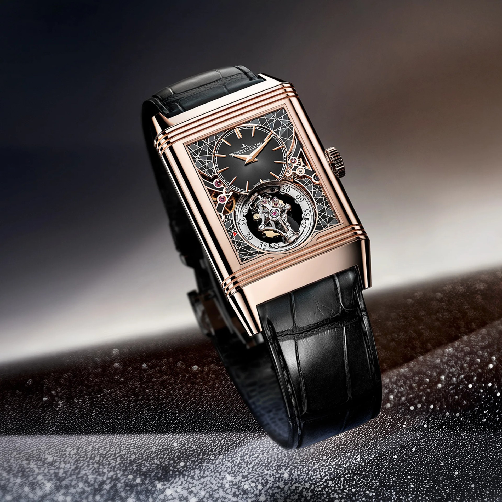 Rectangular rose gold wristwatch with black dial, intricate mechanical details, and black leather strap.