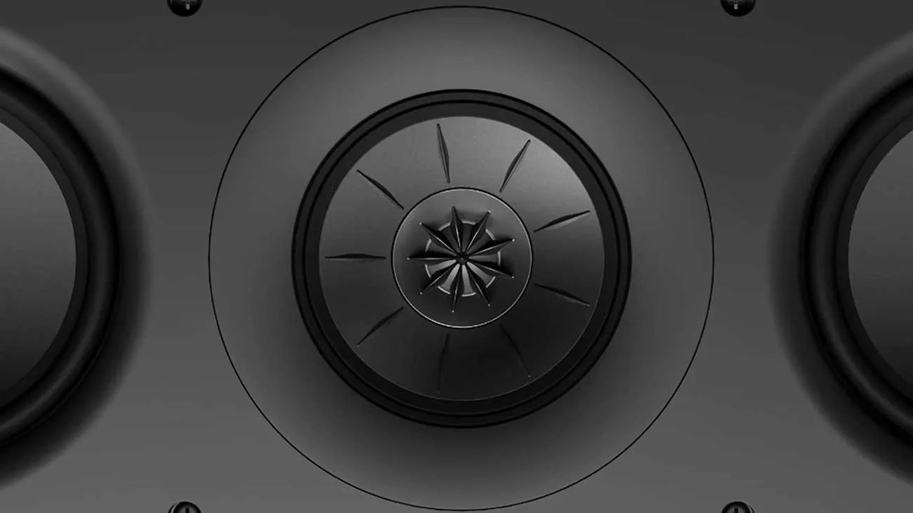 Close-up of a black speaker driver with a central turbine-like design and surrounding circular components.