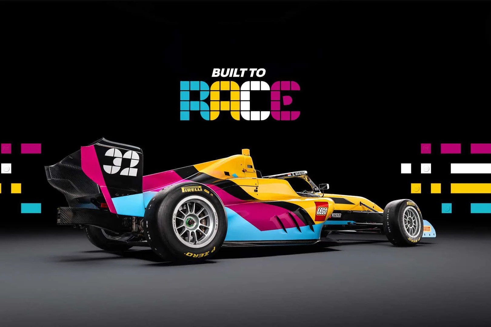 Yellow, magenta, and blue LEGO-themed race car with Pirelli tires on a gray surface with "Built to Race" text above.