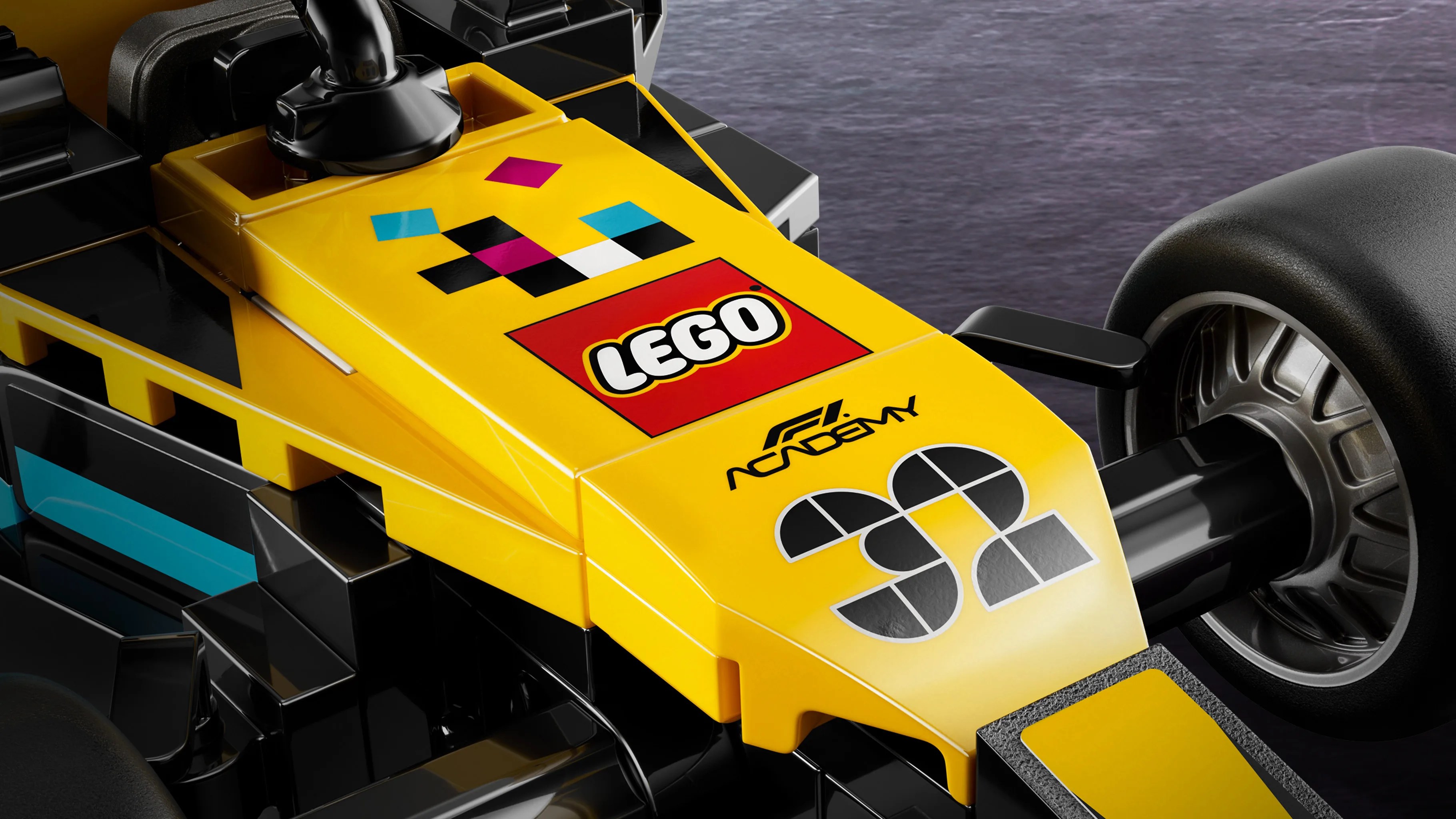 Close-up of a yellow and black LEGO Formula 1 car nose with LEGO and F1 Academy logos and the number 32.