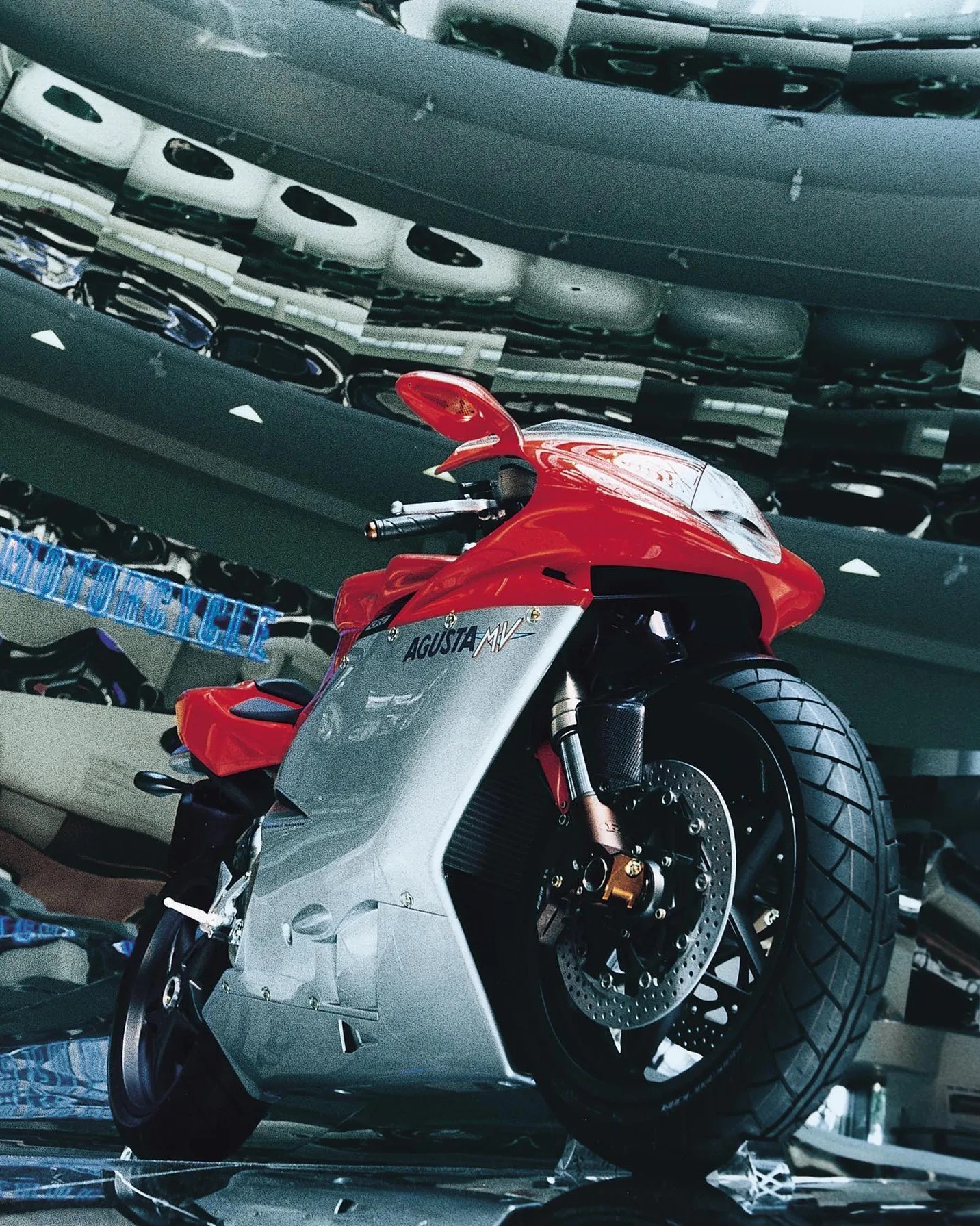 Red and silver MV Agusta sport motorcycle with large front tire in a reflective showroom.