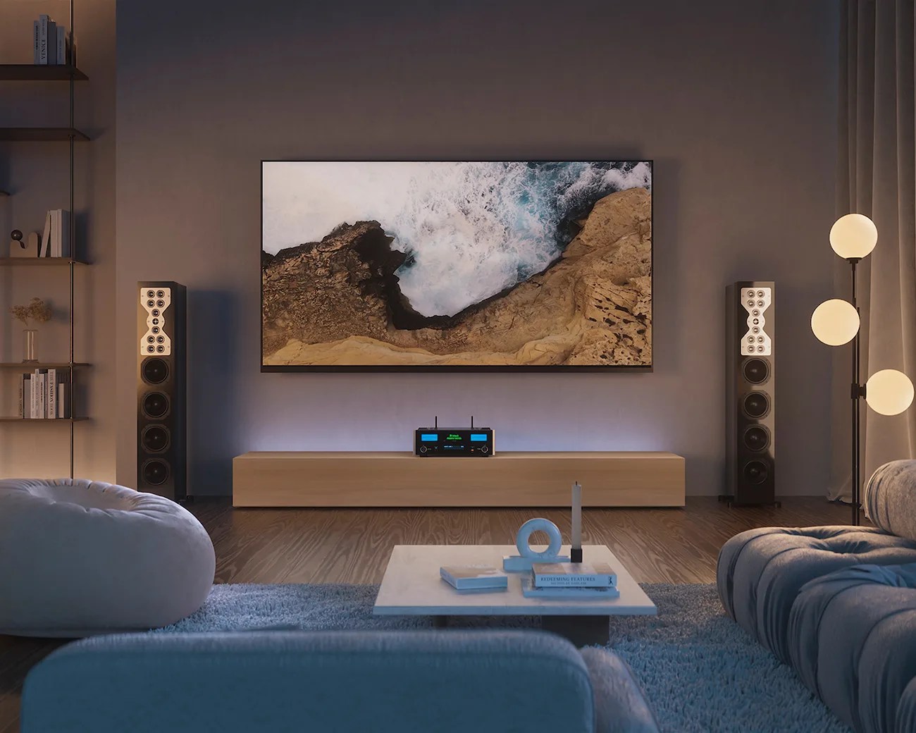 Modern living room with a wall-mounted TV showing ocean waves, two tall black speakers, a wooden media console, and soft seating.