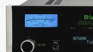 Close-up of a McIntosh MSA5500 integrated amplifier showing power output meter, input knob, and headphone jack.