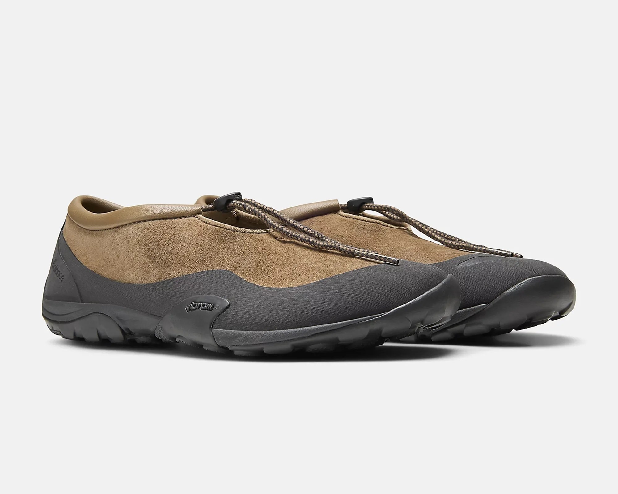 Pair of brown suede slip-on shoes with black rubber soles and elastic bungee laces.