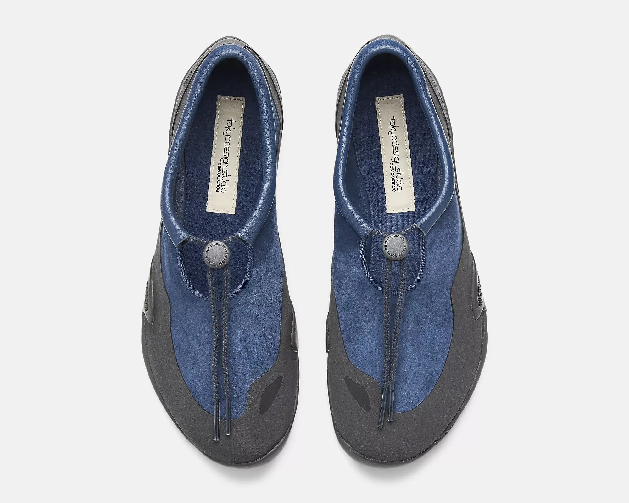 Pair of blue and black slip-on shoes with a round button and drawstring detail on top.