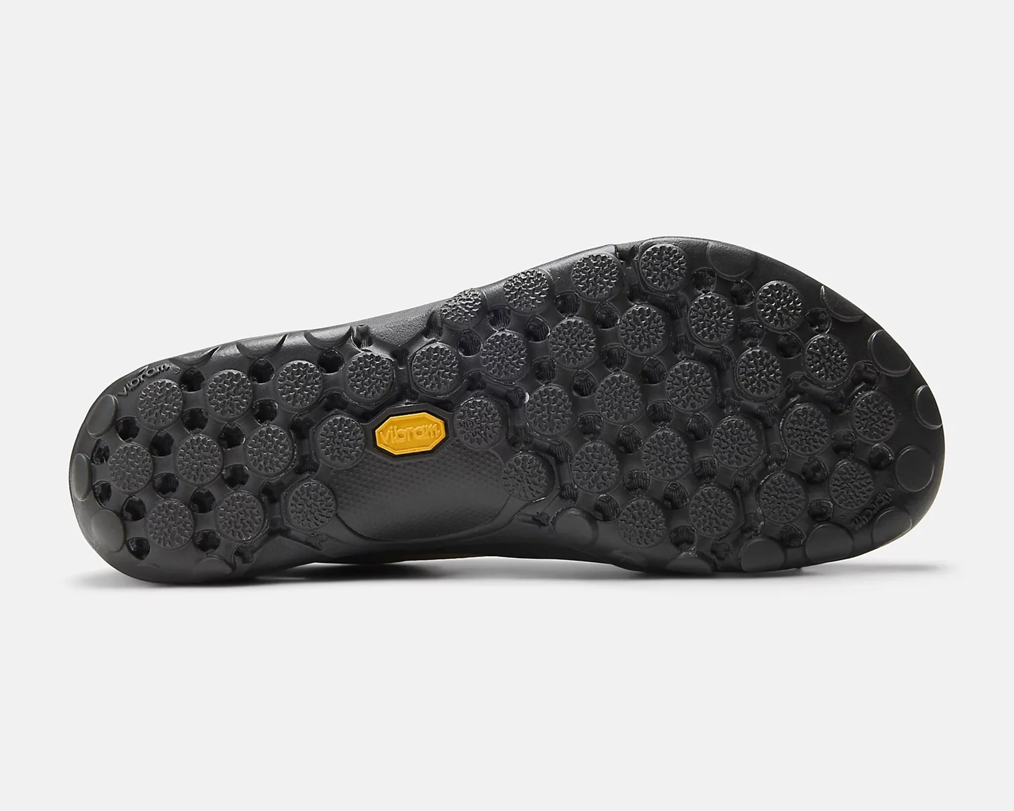 Black Vibram rubber shoe sole with circular textured treads and a yellow Vibram logo in the center.