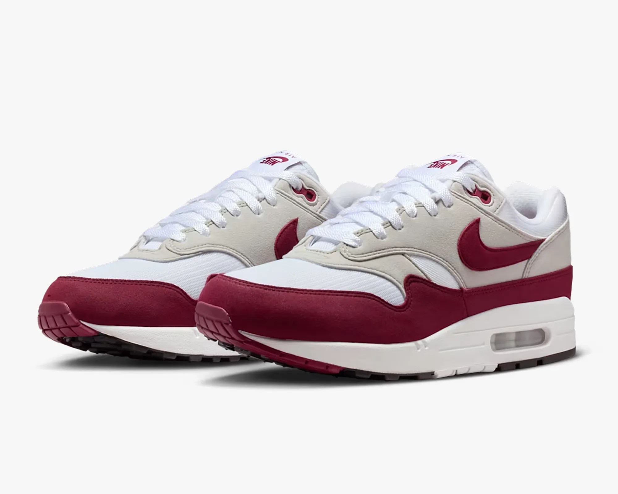 Pair of white and maroon Nike Air Max sneakers with visible air cushion soles.