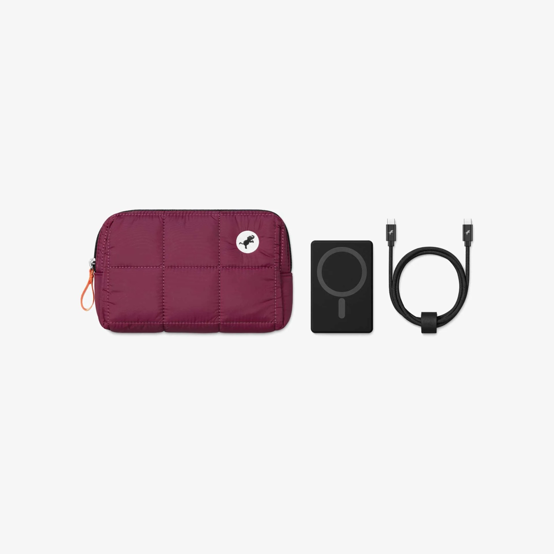 Burgundy quilted pouch with zipper, black wireless charger, and black USB-C cable with connectors.