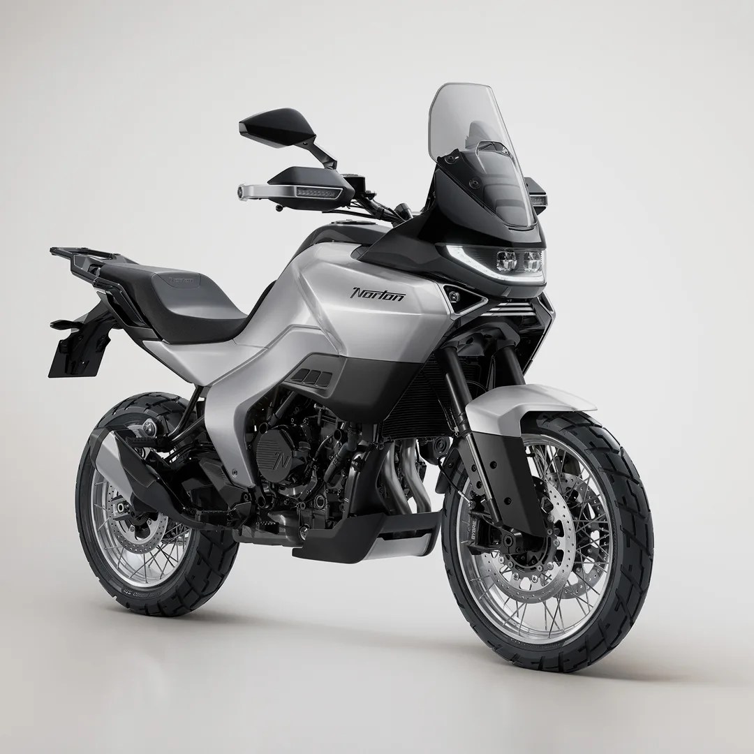 Silver and black Norton adventure motorcycle with tall windshield and knobby tires on a plain background.