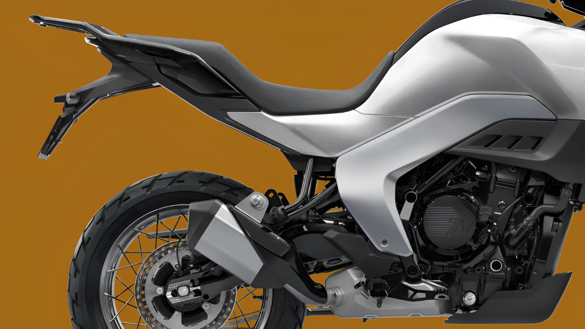 Close-up of the rear half of a silver and black motorcycle showing the seat, exhaust, rear wheel with spokes, and engine components.