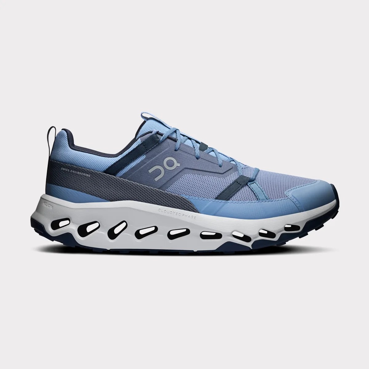Light blue and navy athletic shoe with white sole featuring cutout design and "On" logo on the side.