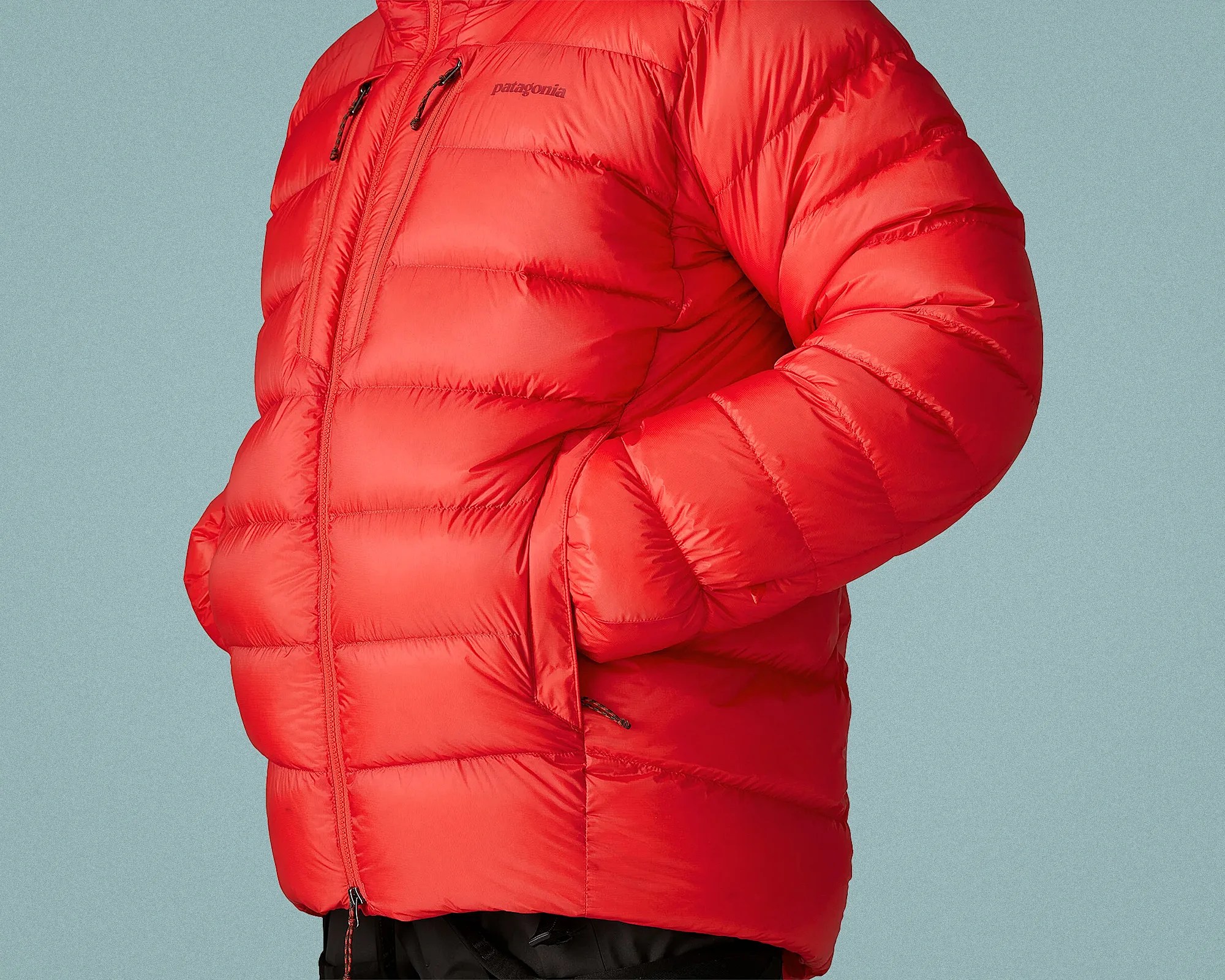 Bright red Patagonia puffer jacket with zippered chest and side pockets worn by a person.