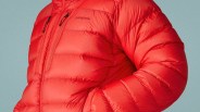 Red Patagonia puffer jacket with chest and side zip pockets against a light blue background.
