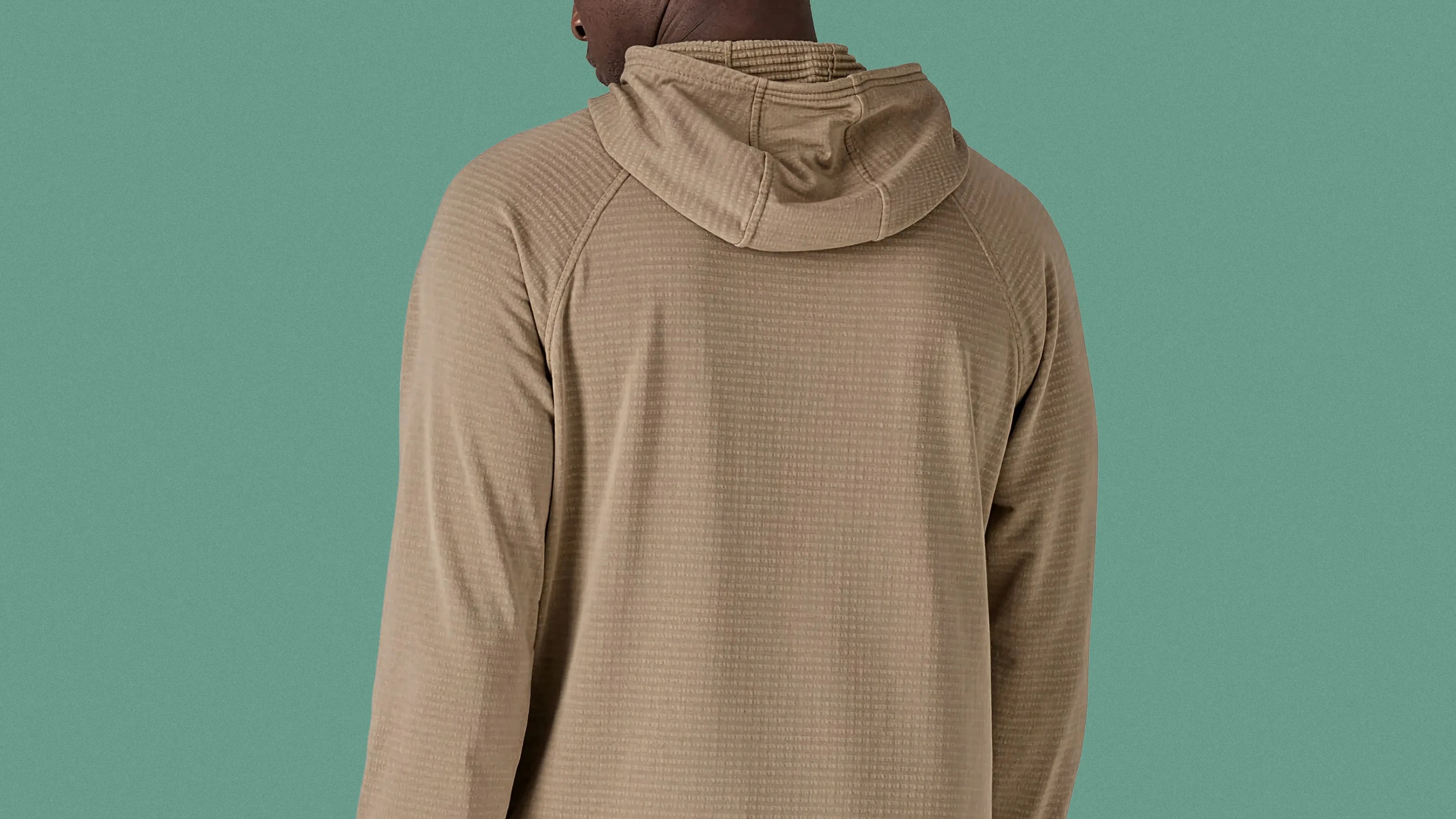 Light brown textured hoodie with a relaxed fit shown from the back against a green background.