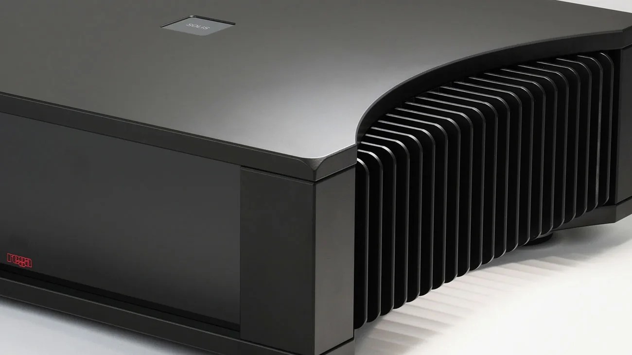 Black rectangular electronic device with a curved top and large heat sink fins on the side.