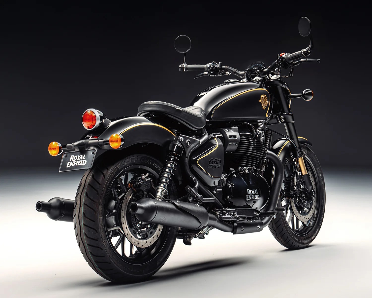 Black Royal Enfield motorcycle with gold pinstriping and dual exhausts on a gradient background.