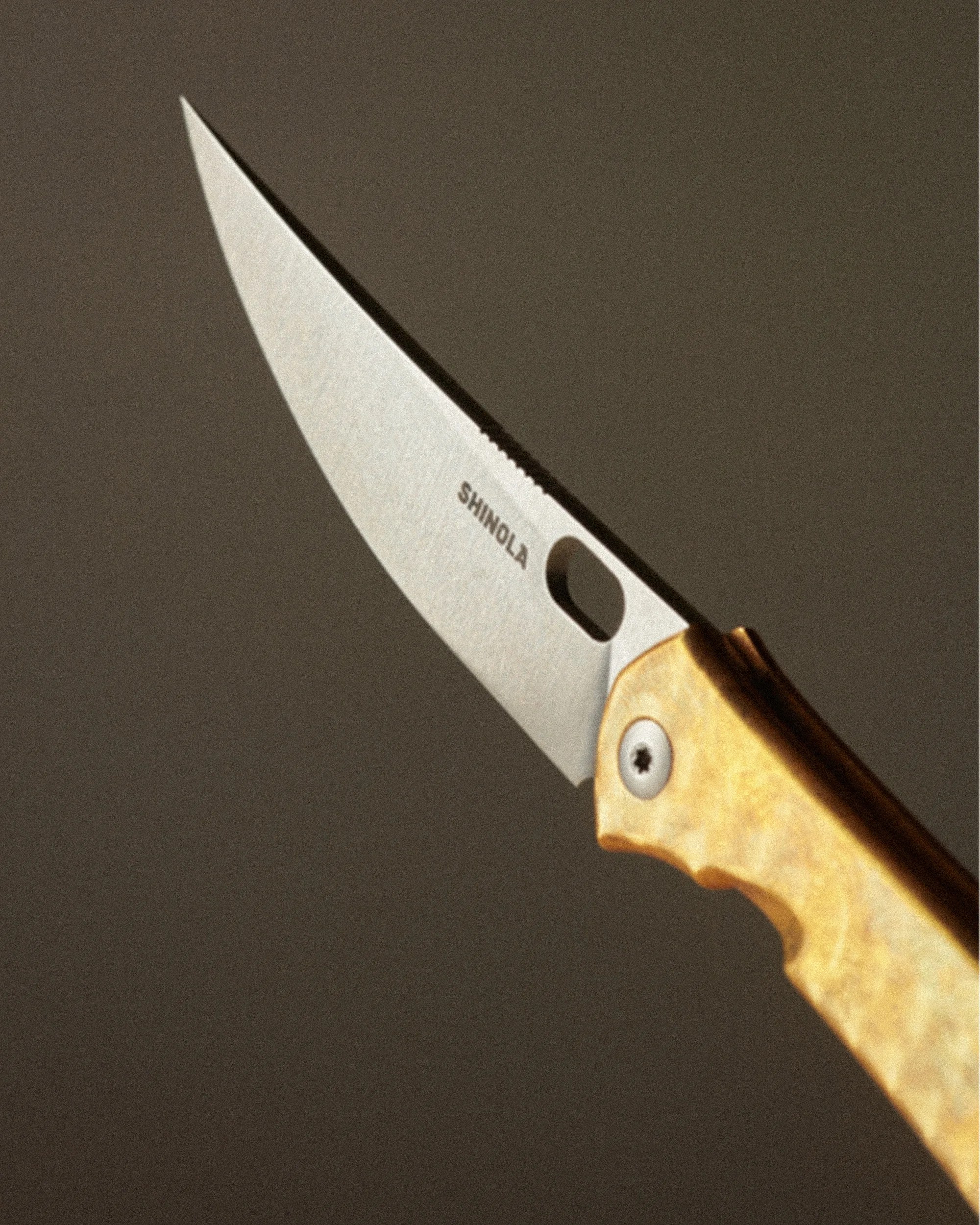 Folding knife with a silver blade engraved "SHINOLA" and a light brown textured handle.