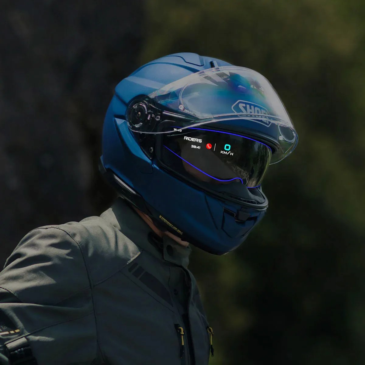 Blue Shoei motorcycle helmet with a transparent visor displaying a digital speedometer and notifications worn by a person.