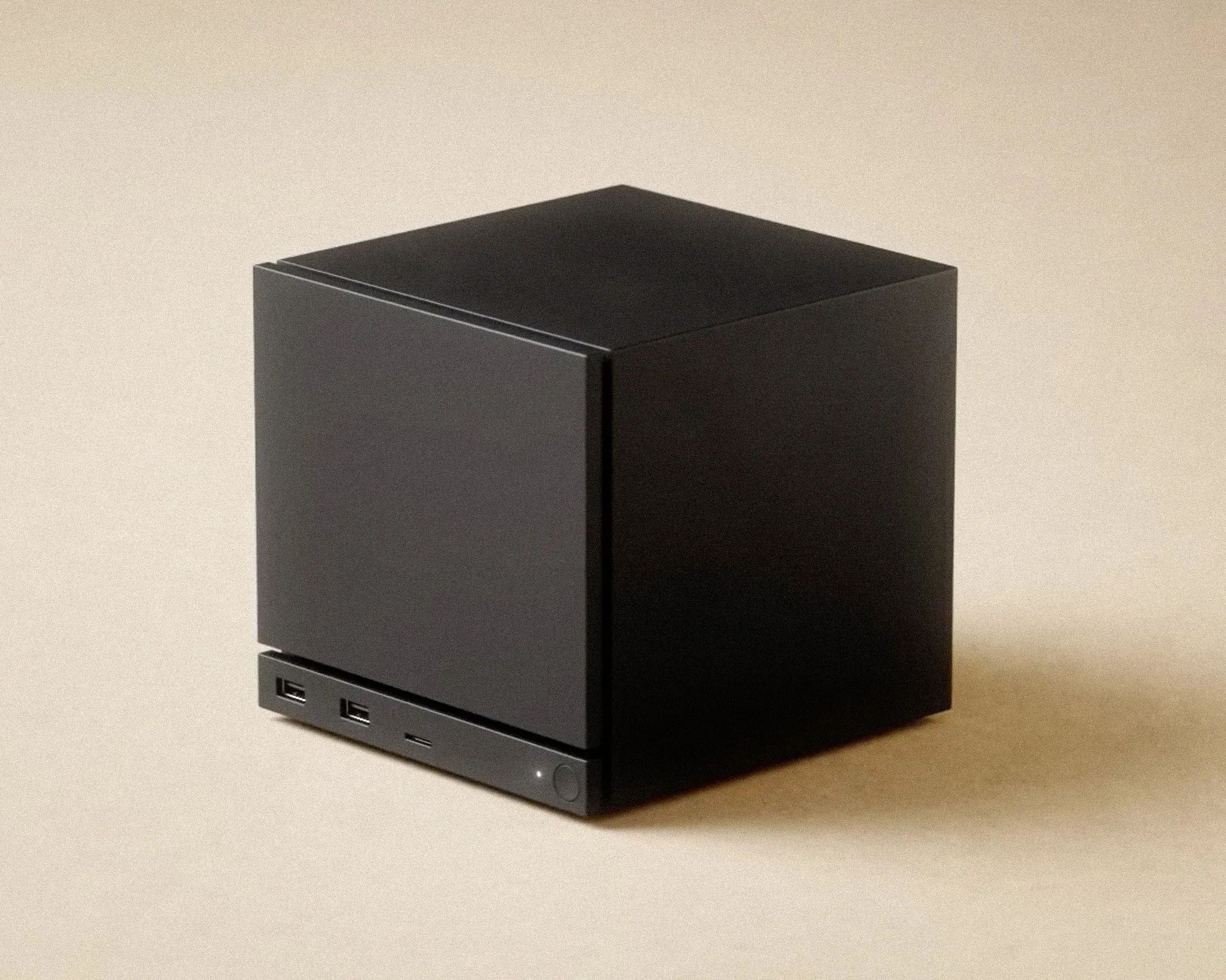 Matte black cube-shaped electronic device with two USB ports and a small button on the front panel.