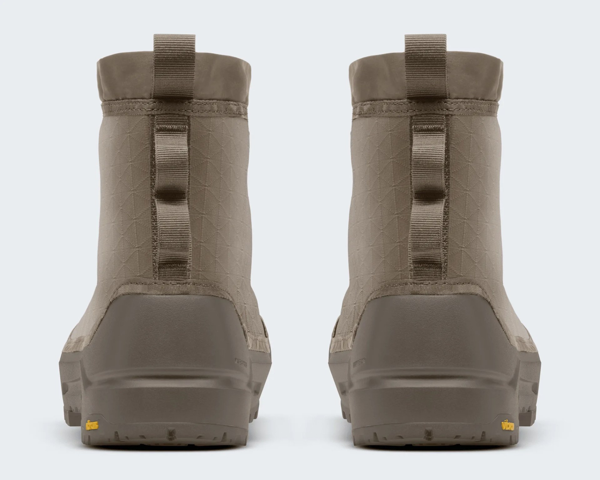 Pair of taupe ankle boots with textured fabric uppers and pull tabs on the back, shown from the rear.