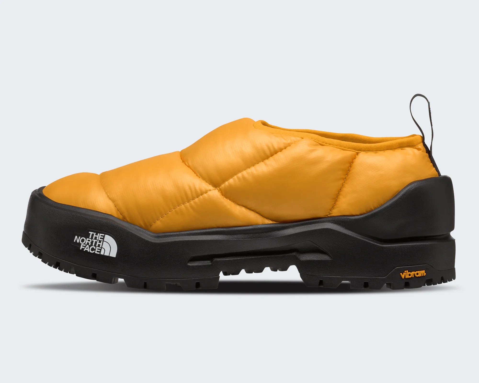 Yellow quilted slip-on shoe with thick black sole and The North Face logo on the side.
