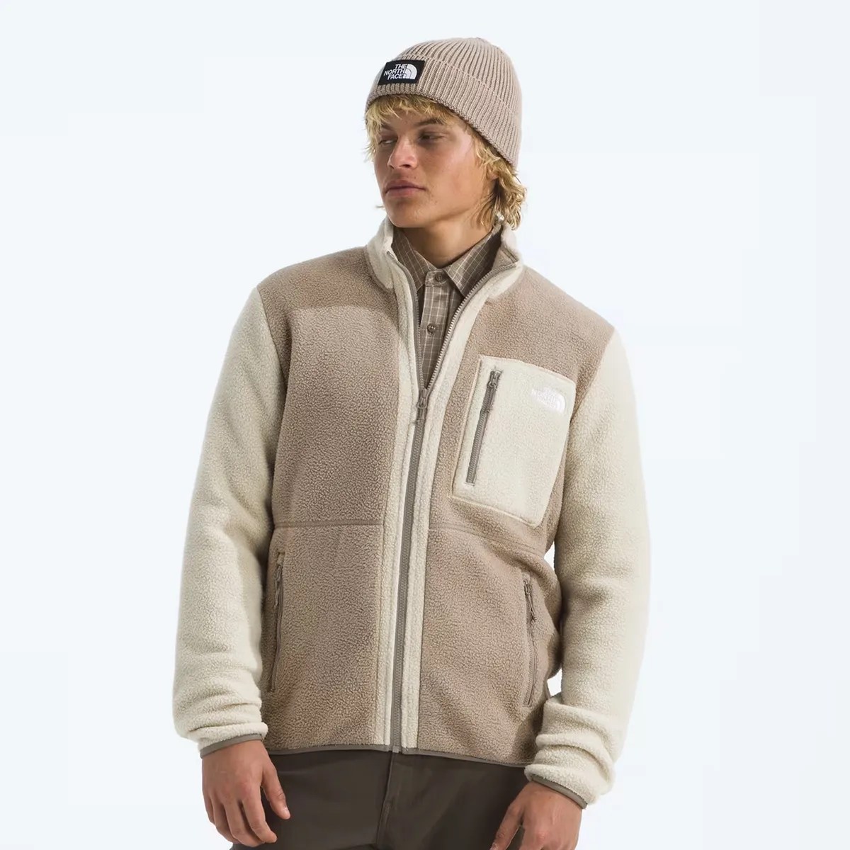 Beige and cream fleece jacket with zippered chest and side pockets worn by a person.