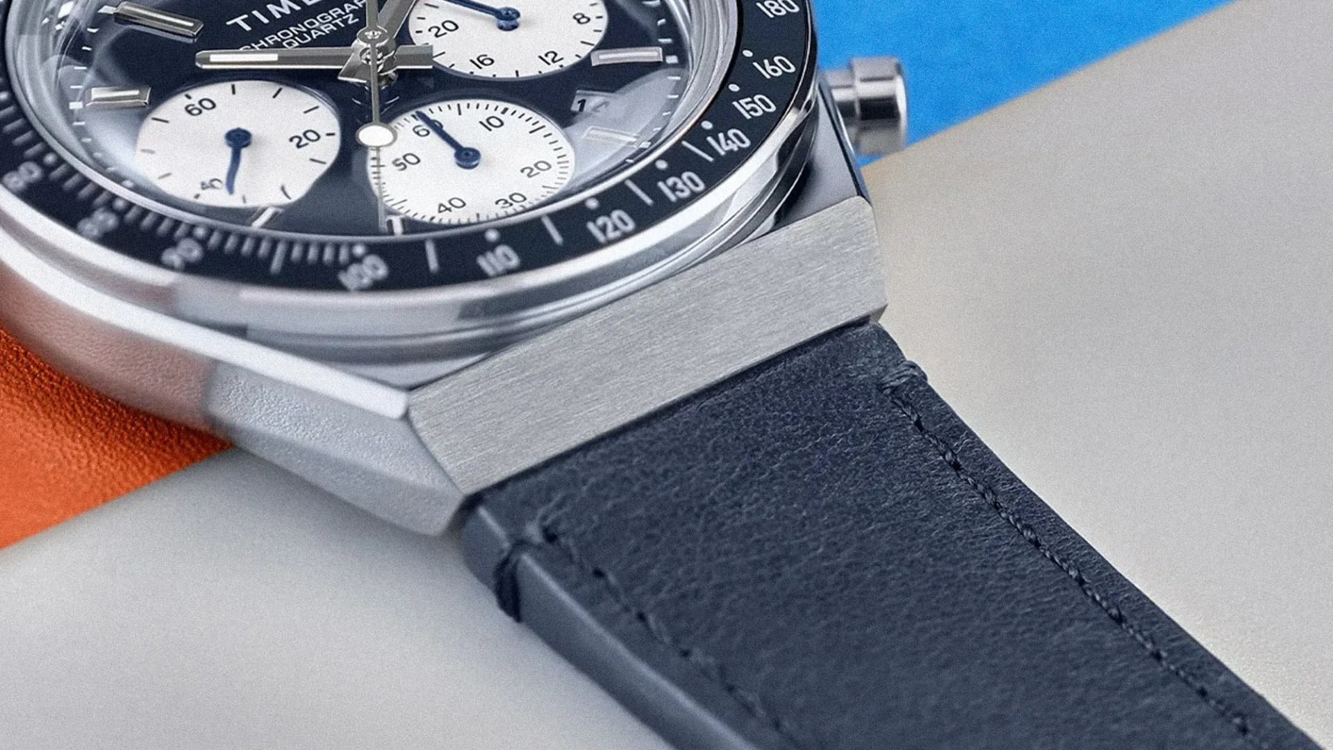 Close-up of a Timex chronograph quartz watch with a black bezel and navy blue leather strap.