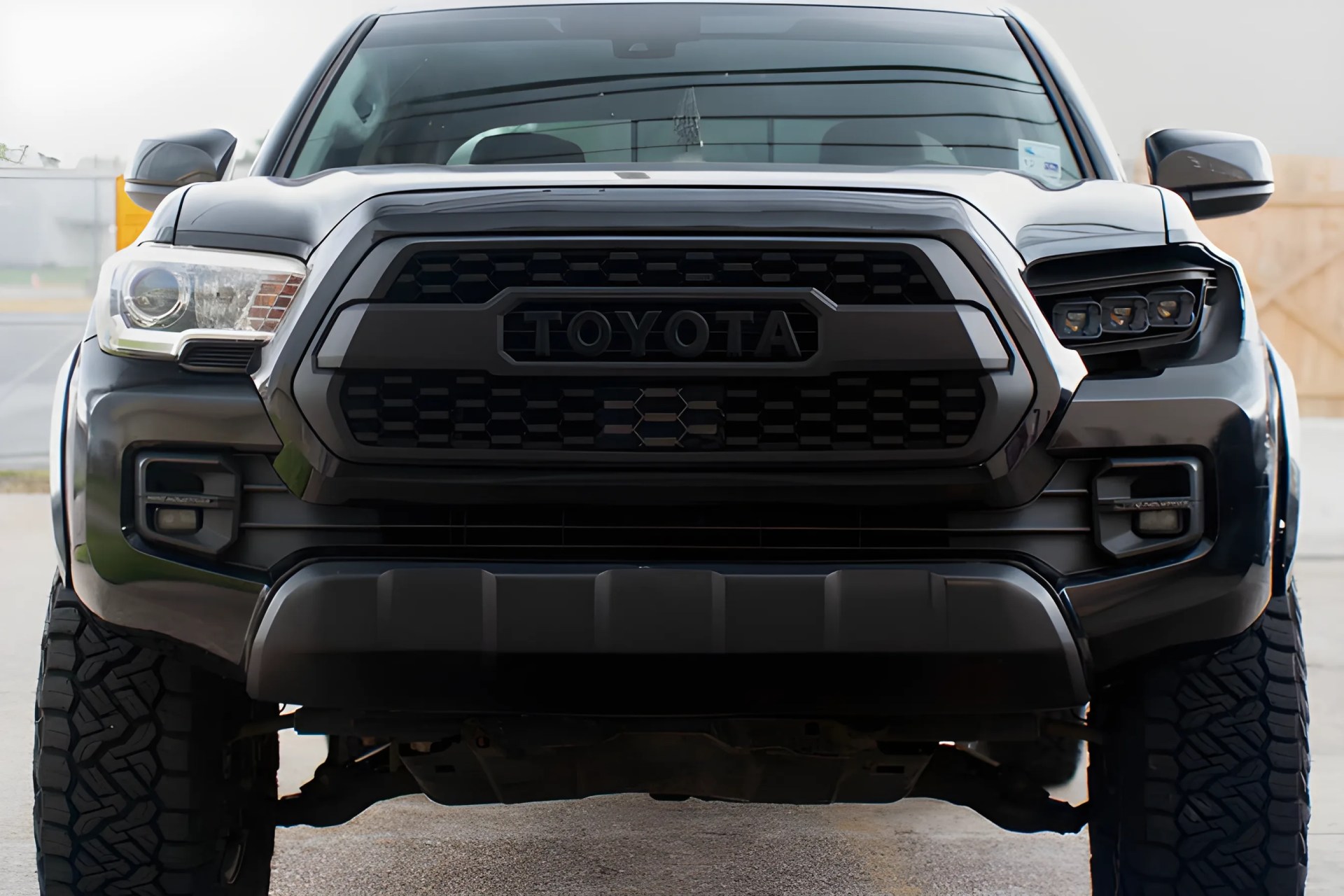 Front view of a black Toyota truck with rugged tires and a bold grille displaying the Toyota logo.