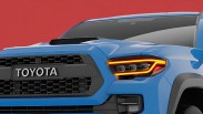 Front view of a blue Toyota truck with black grille and illuminated LED headlights against a red background.