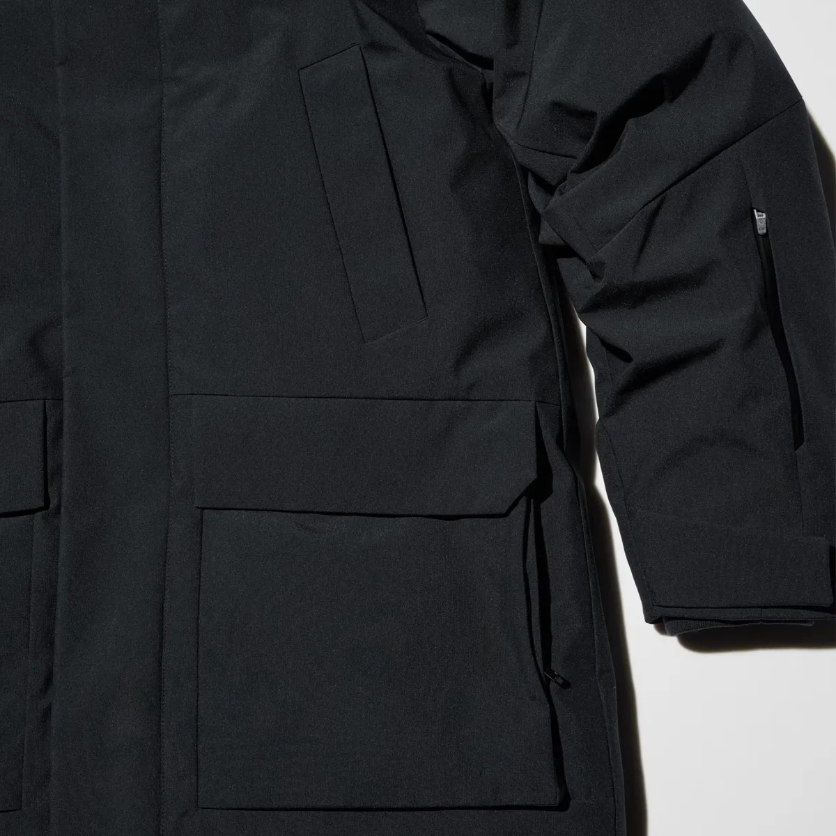 Black jacket with multiple pockets, including a zippered pocket on the sleeve and flap pockets on the front.