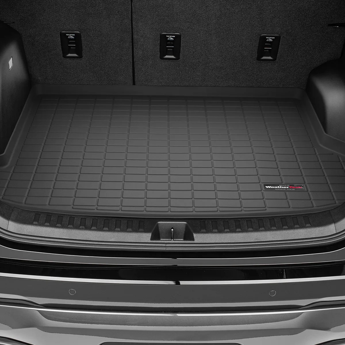 Black WeatherTech cargo liner with grid pattern fitted in a vehicle trunk.