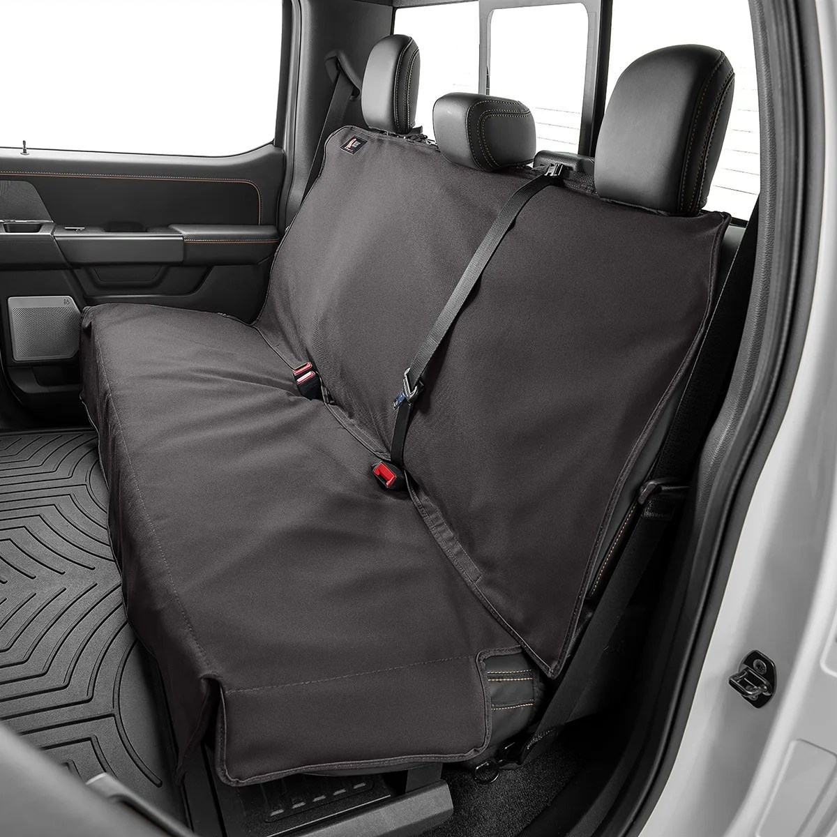 Black waterproof bench seat cover installed on the rear seat of a pickup truck.