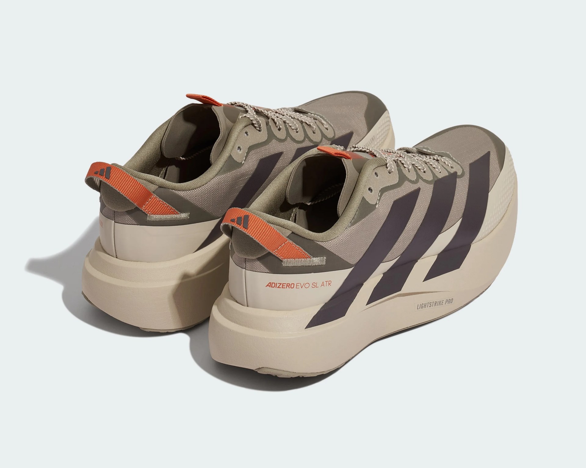 Pair of beige and olive Adidas Adizero Evo SL ATR running shoes with black stripes and orange heel tabs.