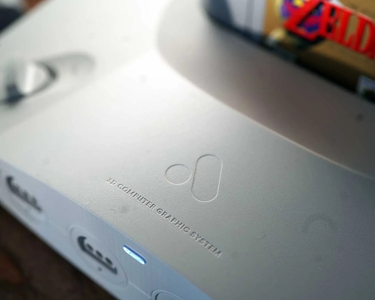 Close-up of a white 3D Computer Graphic System device with embossed logo and text on the top surface.