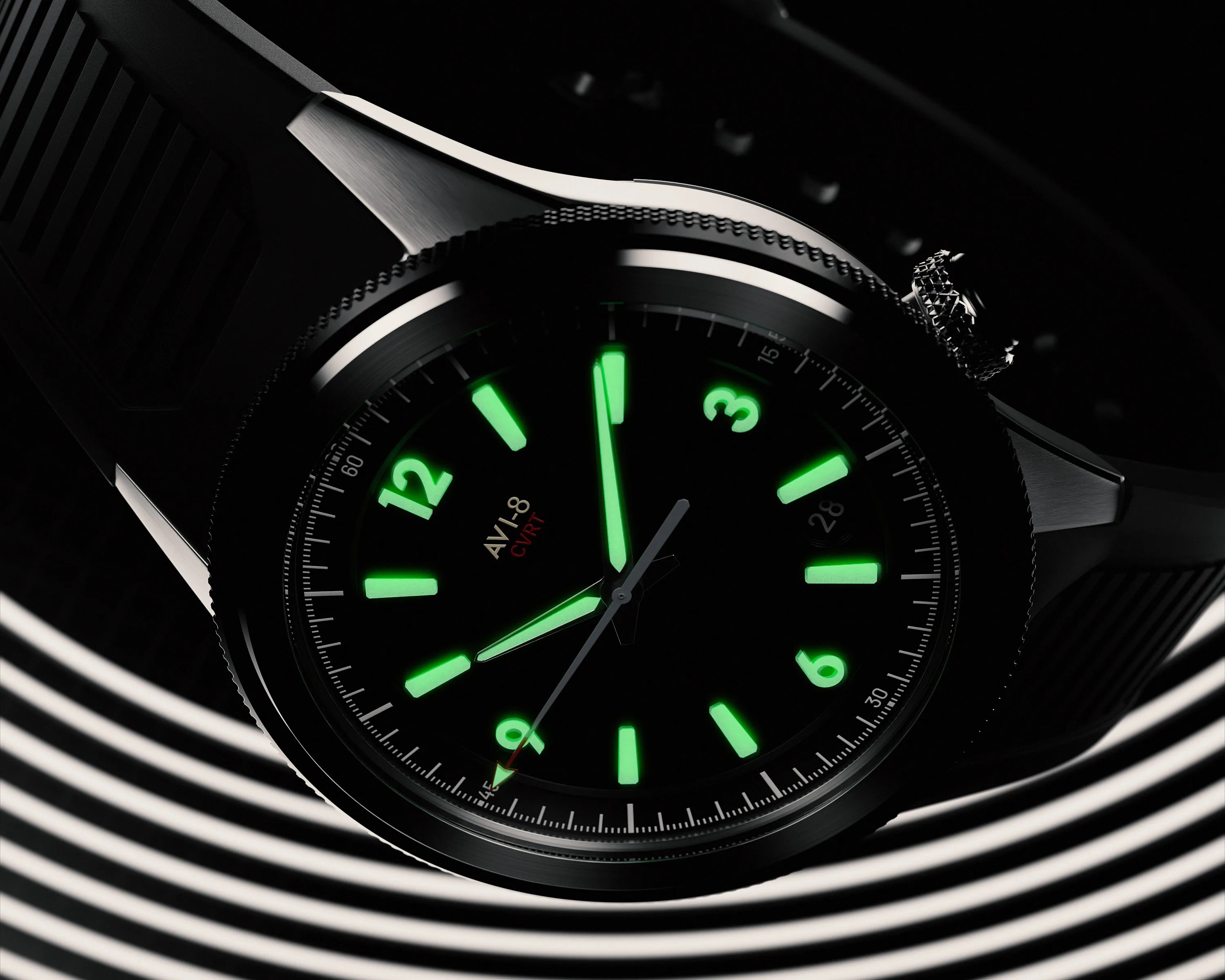 Black AVI-8 wristwatch with green luminescent hour markers and hands on a striped black and white background.