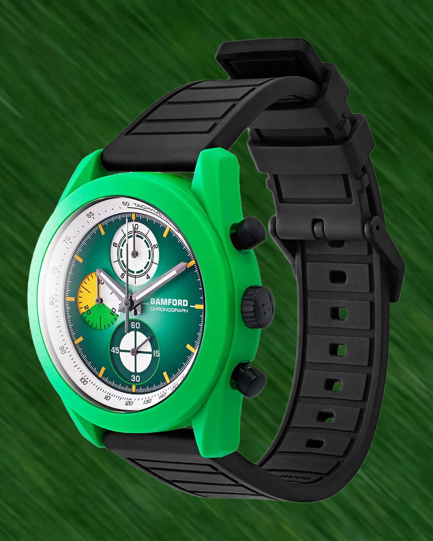Green Bamford chronograph watch with black rubber strap and multicolored subdials on a green background.