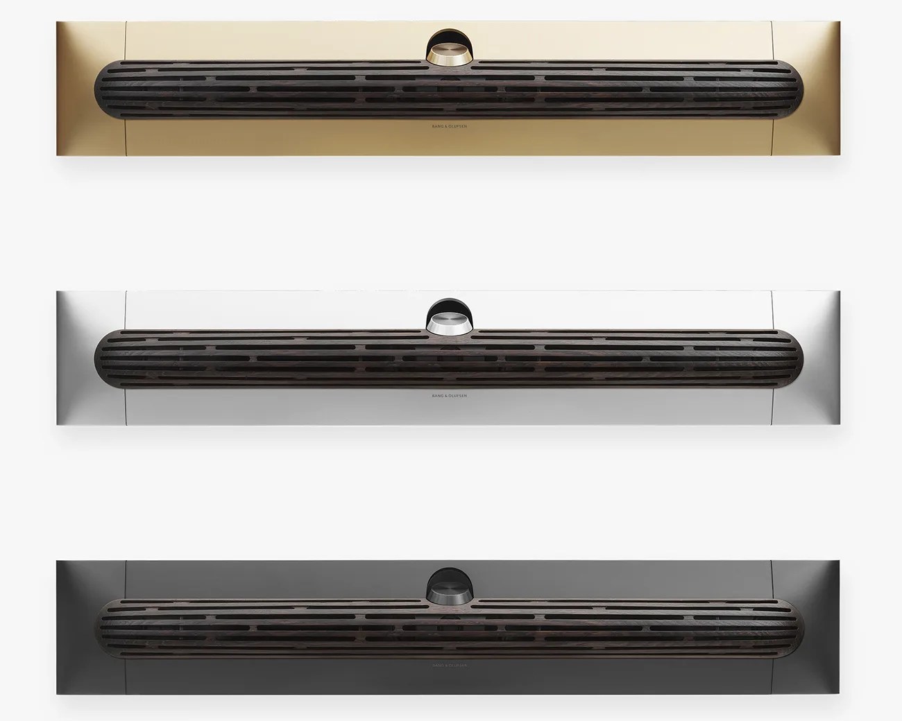 Three horizontal Bang & Olufsen speakers in gold, silver, and black finishes with black wooden grilles.
