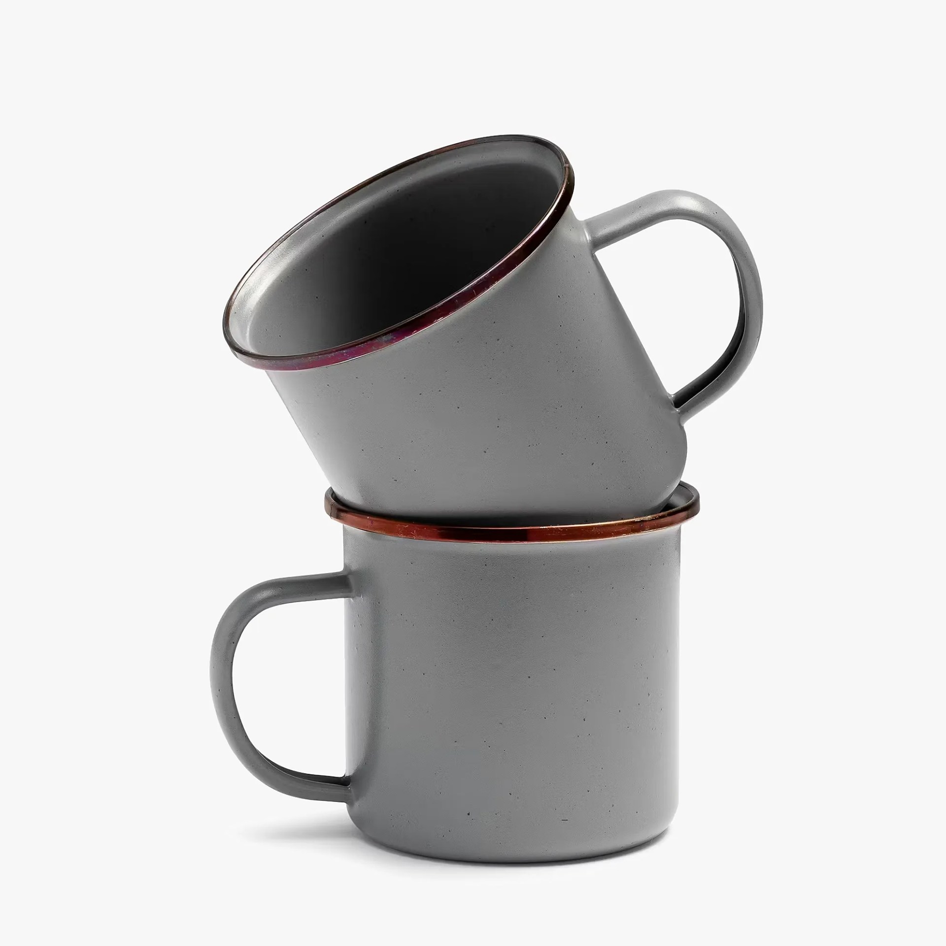 Two gray metal mugs with copper rims stacked on a white background.
