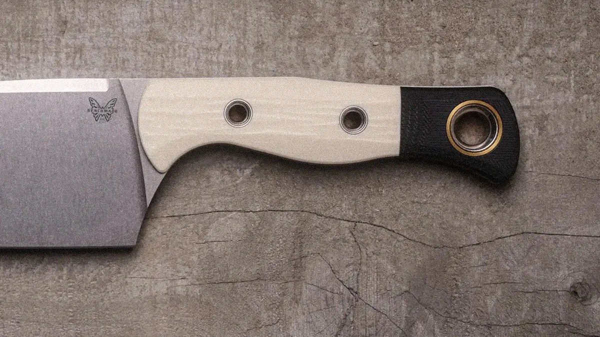 Knife with a wide stainless steel blade and a handle featuring light wood and black sections with metal rivets and a lanyard hole.