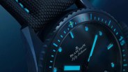 Close-up of a blue Blancpain Fifty Fathoms watch face with blue luminescent markers and a textured black strap.