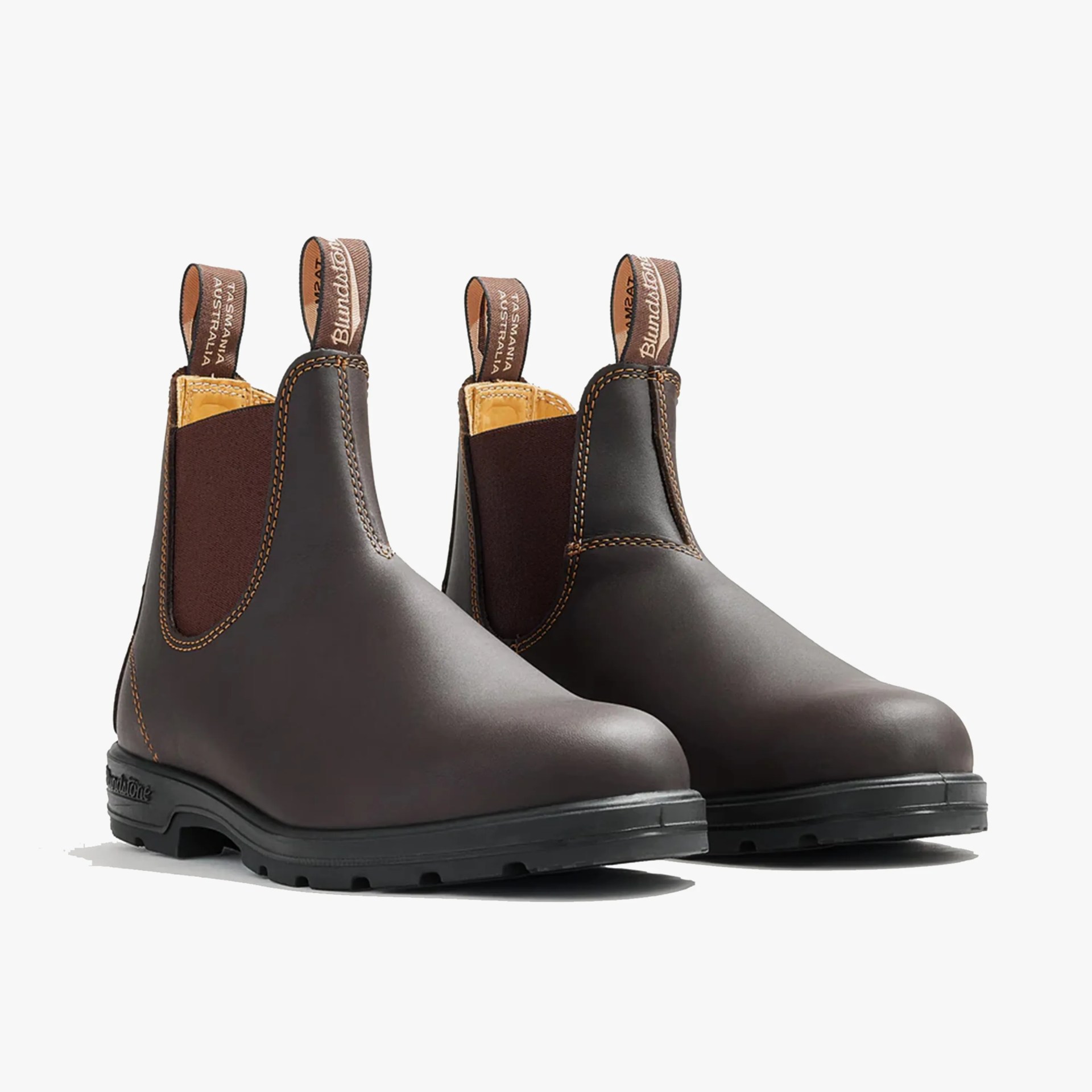 Pair of dark brown leather Chelsea boots with black rubber soles and branded pull tabs.
