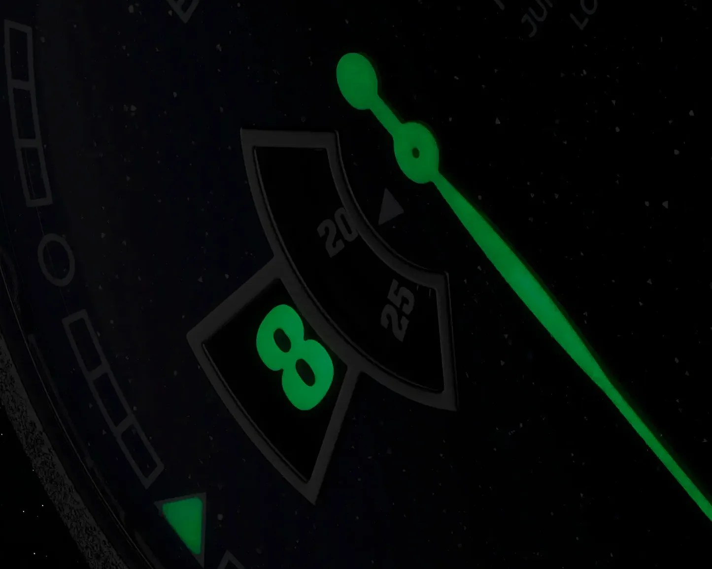 Close-up of a watch dial showing glowing green hands and the number 8 in a date window.