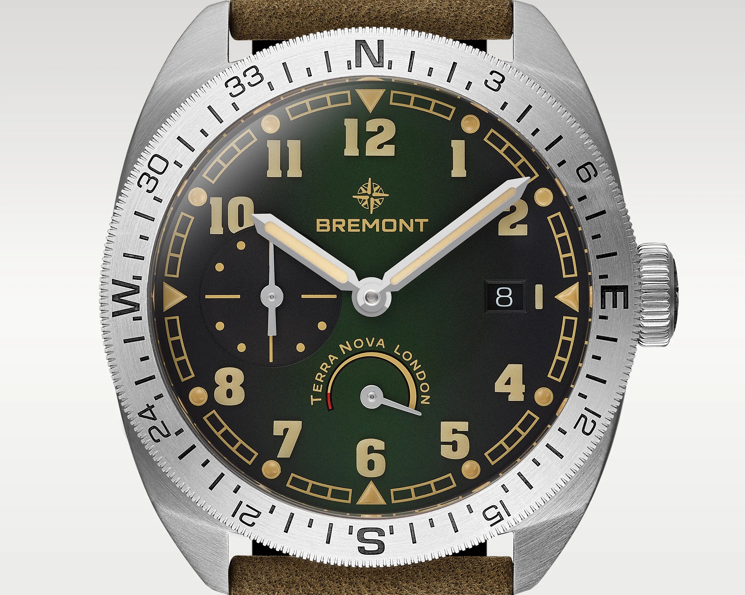 Close-up of a Bremont Terra Nova London watch with a green dial, beige numerals, silver bezel with compass markings, and brown leather strap.