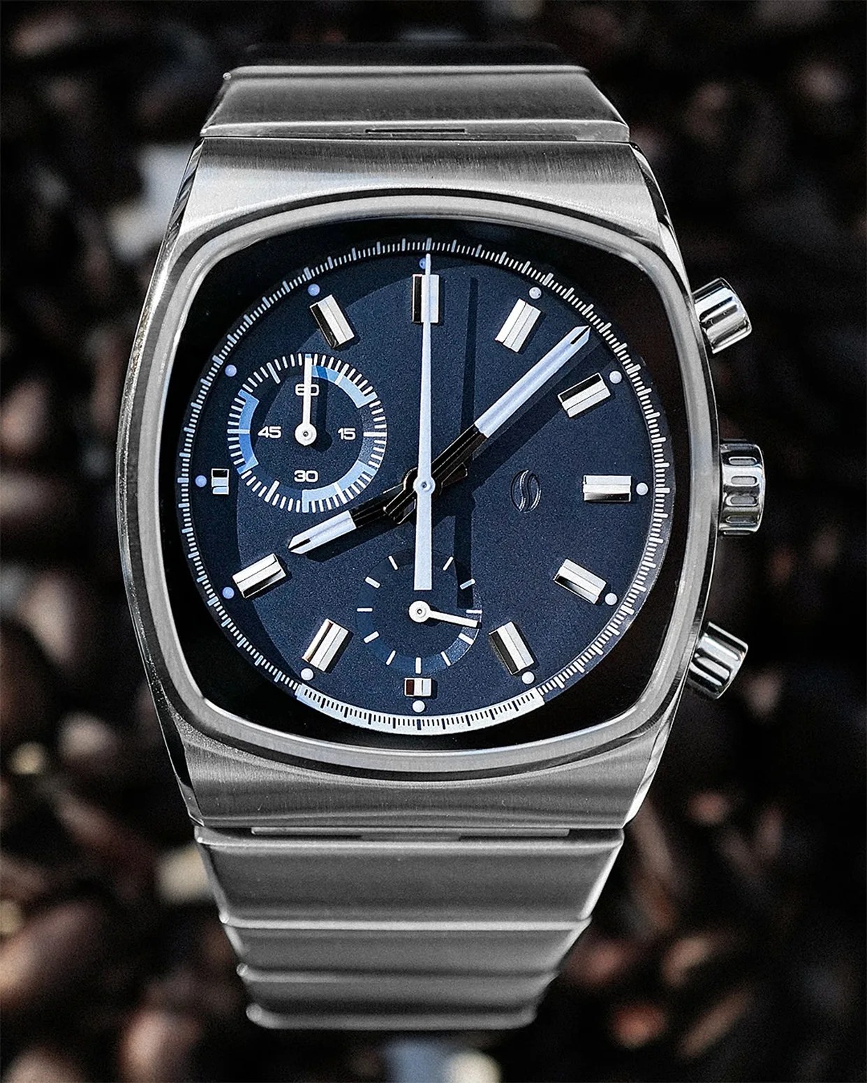 Stainless steel wristwatch with a blue dial, chronograph subdials, and a matching metal bracelet.