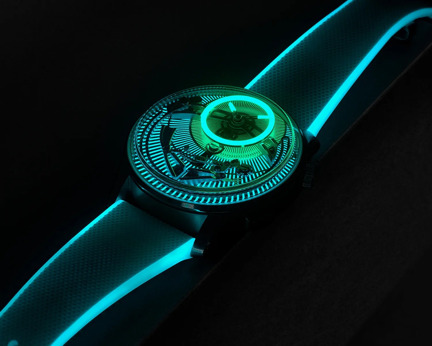 Close-up of a wristwatch with glowing blue-green luminescent dial and strap edges in a dark setting.