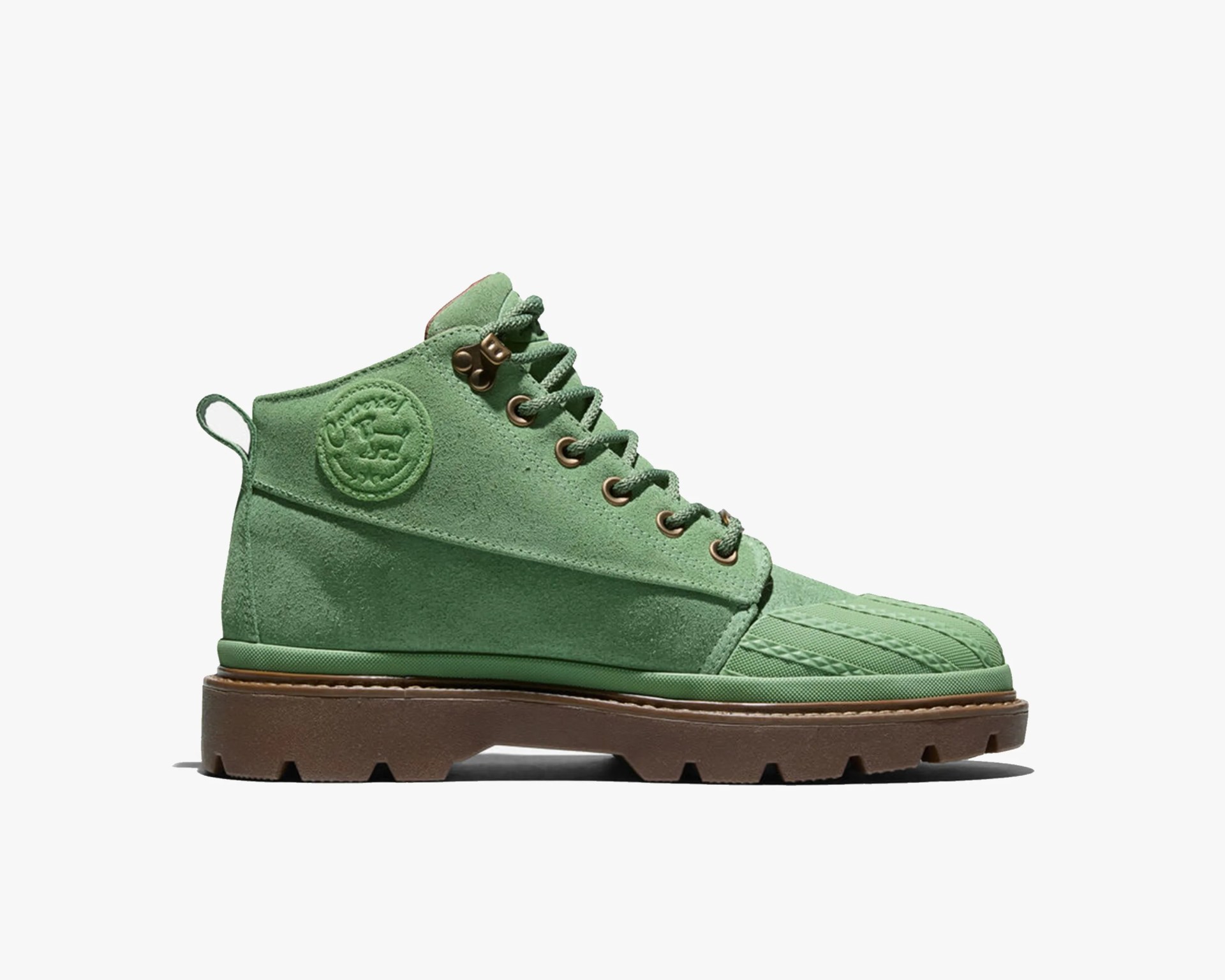 Green suede ankle boot with brown lug sole and embossed circular logo on the side.